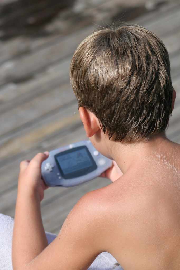 Boy playing Gameboy - Video Games Can Now Tap in to Players’ Emotions - Humintell 